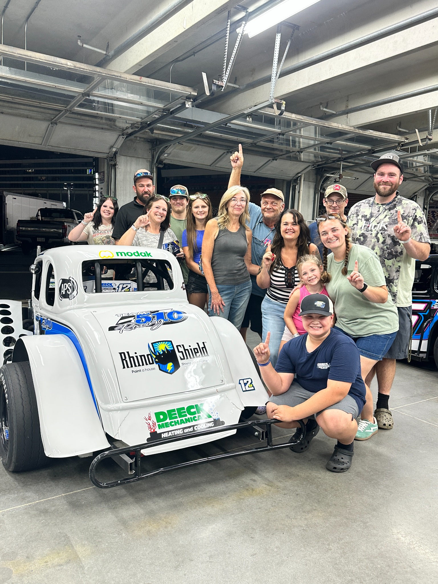 Jaxon with his supporters beside his Legend car in the garage